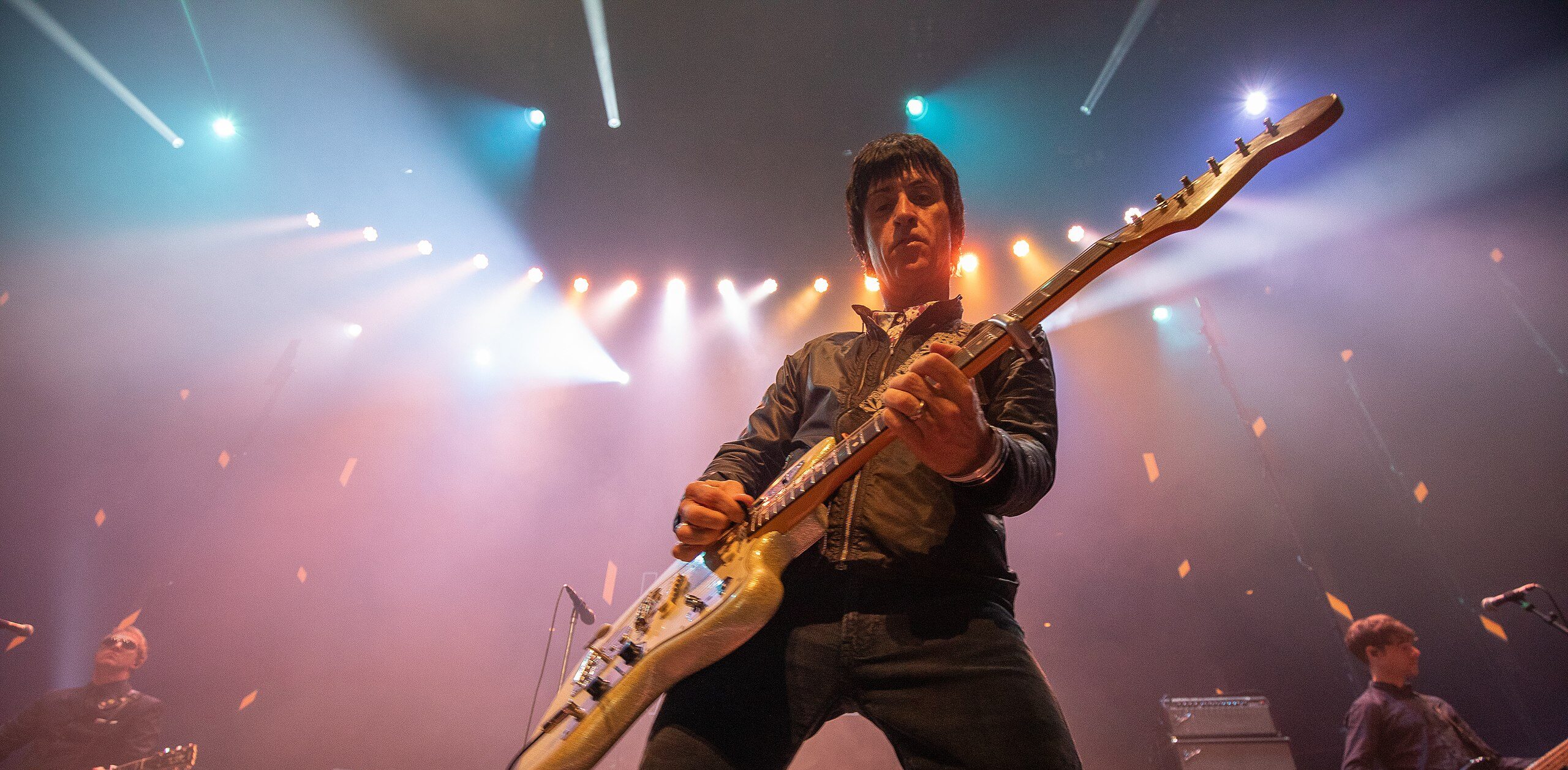 Johnny Marr playing guitar on stage.